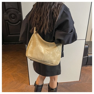 Modern light yellow hobo bag shown with vertical stitching on matte leather finish