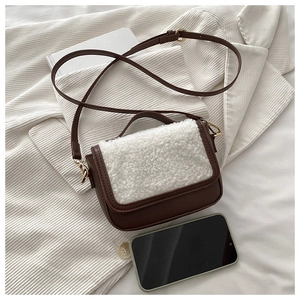 Detail of winter crossbody bag with brown faux leather and white shearling trim texture
