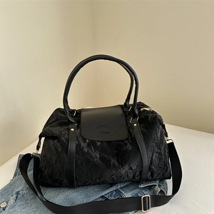 Grand sac de voyage noir à texture plissée avec poignées en cuir et bandoulière