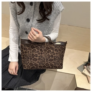 Detail of vintage leopard rose print tote bag with brown leather trim and gold metal logo