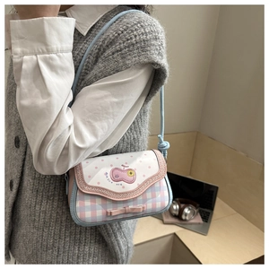 Détail du motif cerise brodé et du nœud rose sur le sac à bandoulière à carreaux