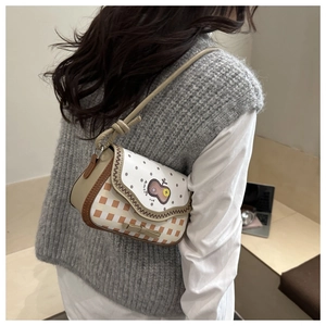 Detail of cute fruit embroidery and wavy stitching on orange plaid crossbody bag