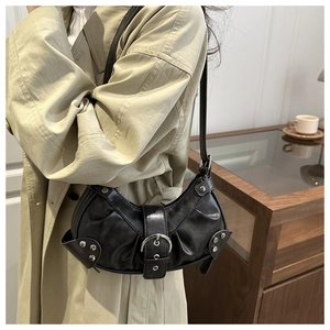 Detail of vintage pleated shoulder bag featuring silver metal buckle and rivet accents