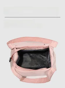 Detail view of pink nylon bucket bag interior showing black lining and zip closure