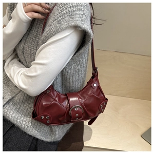 Detailed side view of a burgundy Y2K underarm bag featuring silver rivets and metal buckle
