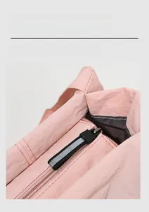 Detail of high-quality smooth zipper and black woven puller on a pink bucket bag