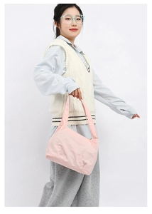 Detailed texture of soft pink nylon bucket bag with wide shoulder strap design