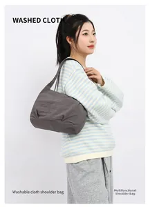 Detail of dark grey washed fabric bucket bag showing lightweight texture on a model