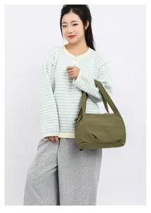 Detailed view of the grass green nylon bucket bag with a puffy quilted texture and wide strap