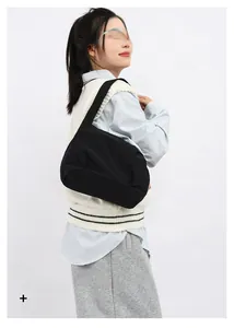 Detailed view of a black crescent shoulder bag shown on a model for size and style