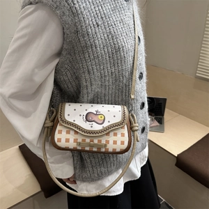 Cute apple-themed shoulder bag with beige polka dots and orange plaid pattern on a model