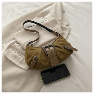 Detail der grünen Canvas-Schultertasche mit Leder-Zierschnallen und Falten-Design