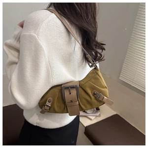 Detail of vintage canvas shoulder bag with premium leather trim and large metal buckle
