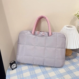 Detalle del bolso acolchado lavanda con asas rosas y tirador de cremallera