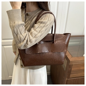 Detailed texture of dark brown crocodile pattern tote bag with long shoulder straps