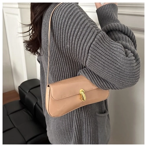 Détail du sac baguette en cuir verni beige brillant avec élégant fermoir doré