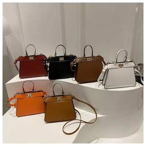 Détail de sacs à main trapèze multicolores avec fermoir tournant métallique et poignée