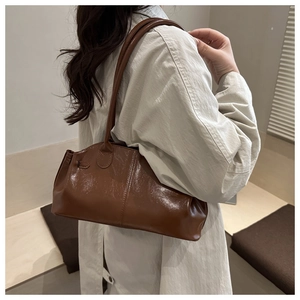 Detail der glänzenden braunen Boston Bag mit Fokus auf Lack-Finish und vertikalen Nähten