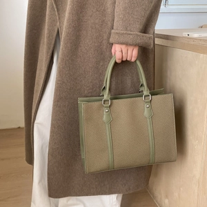 Detail of khaki woven canvas and olive green leather trim on a vintage crossbody bag