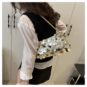 Détail du sac à bandoulière à paillettes argentées sur modèle montrant la texture