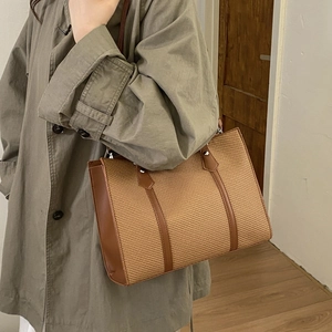 Detail of vintage woven tote bag with brown leather straps and metal rivet accents