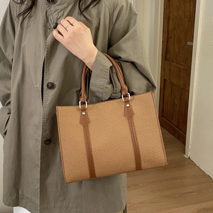 Detail of vintage square tote bag with contrast stitching and textured weave pattern