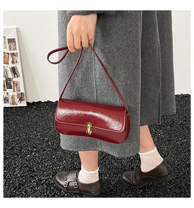 Detailed close-up of a vintage dark red oil-wax leather shoulder bag with a gold lock