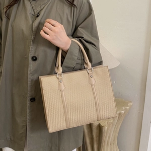Vintage color-block tote bag with beige weave and khaki leather trim carried by a model