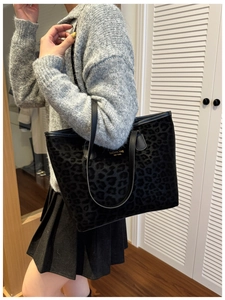 Detail of high-capacity leopard print tote bag with stylish leather straps on model