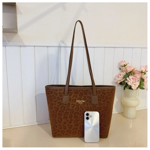 Detailed view of leopard print tote bag interior capacity with smartphone for size reference