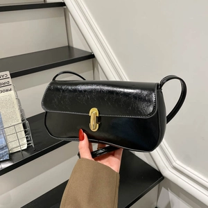 Glossy black patent leather rectangular shoulder bag with golden lock on stairs