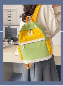 Detailed back view of a student wearing a color-block patchwork nylon school backpack