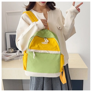Close-up of yellow and green backpack with drawstring side pockets and logo detail