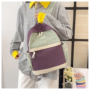 Detail of color-block nylon backpack with crinkled texture and logo pocket detail