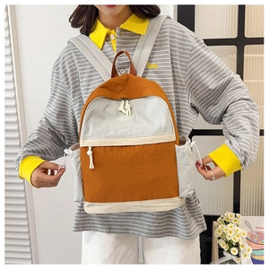 Detail of color-block backpack with orange and gray panels and adjustable straps