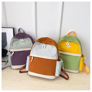 Three color-block backpacks in purple, caramel, and green with drawstring side pockets
