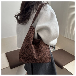 Detailed view of the leopard print tote bag being worn to show its large capacity and style