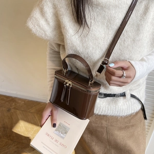Classic dark brown glossy box bag with top handle and golden double zipper closure