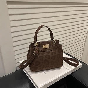 Suede leopard print handbag with golden twist lock and adjustable shoulder strap