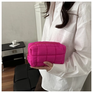 Close-up of vibrant rose pink quilted nylon clutch bag with square puffer pattern