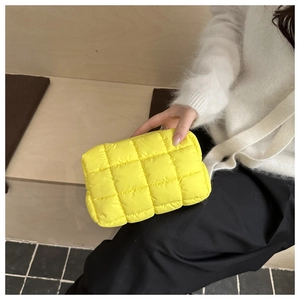 Dettaglio di una borsa trapuntata giallo brillante con trama a griglia a sbuffo