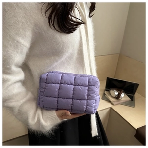 Close-up of a purple quilted makeup bag with soft downy texture and sleek zip closure