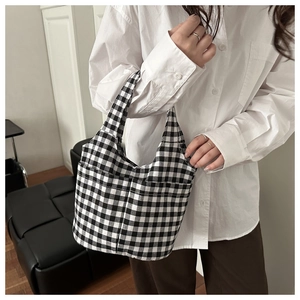 Detail of checkered tote bag showing symmetrical front pockets and soft canvas texture