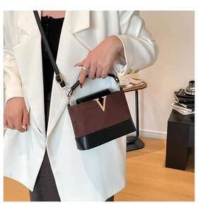 Détail du sac à main en daim marron matelassé avec logo V doré et garniture noire