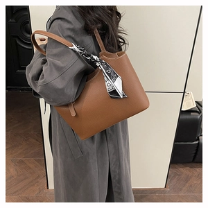 Brown lychee leather tote bag with silk scarf detail shown on shoulder for daily commute