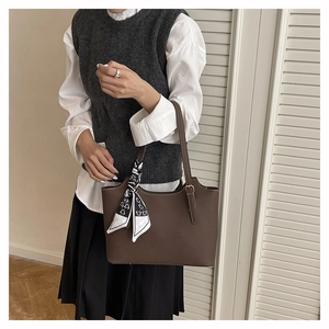 Close-up of a dark brown tote bag featuring litchi texture and heart print silk scarf