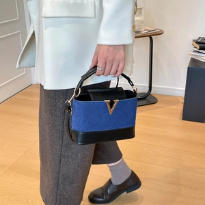 Sac à main bleu et noir matelassé avec boucle dorée en V et bandoulière amovible élégante