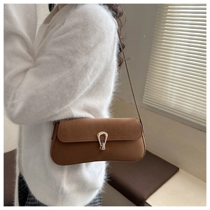 Detail shot of the brown faux suede underarm bag with a vintage silver metal buckle