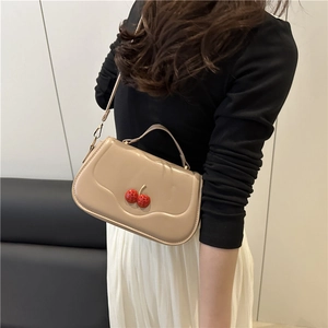 Elegant khaki shoulder bag with red cherry metal buckle shown on a model