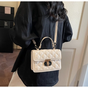 Detail of white quilted handbag featuring classic diamond stitching and elegant dual-tone lock